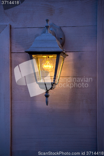 Image of Old lantern burning on the wooden walls