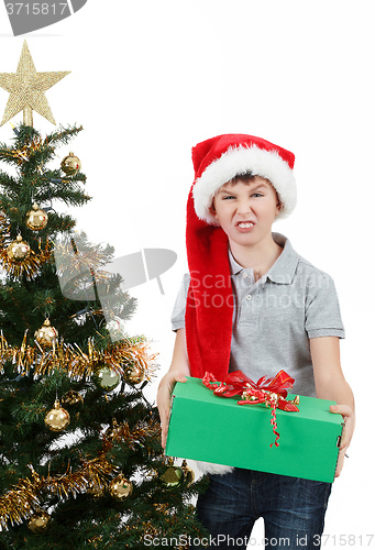 Image of happy boy in santa hat surprised by christmas present