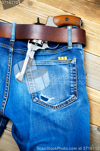 Image of revolver under a leather belt