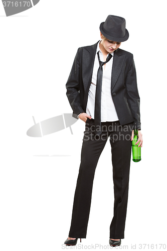 Image of businesswoman wearing a hat and tie, holding bottle of alcohol. Isolated on white background