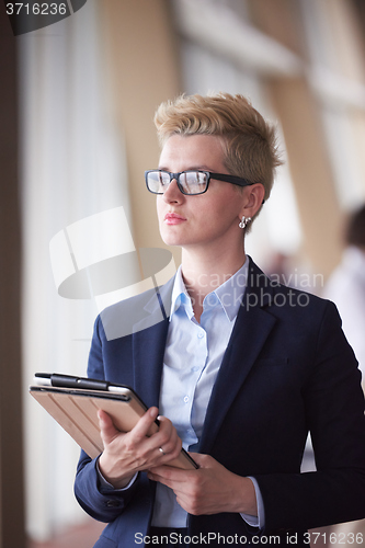 Image of business woman with glasses  at office with tablet  in front  as