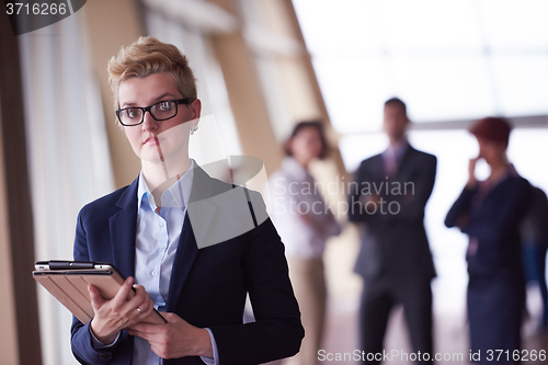 Image of business woman with glasses  at office with tablet  in front  as