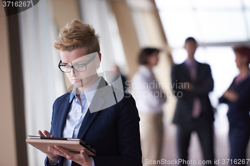 Image of business woman with glasses  at office with tablet  in front  as