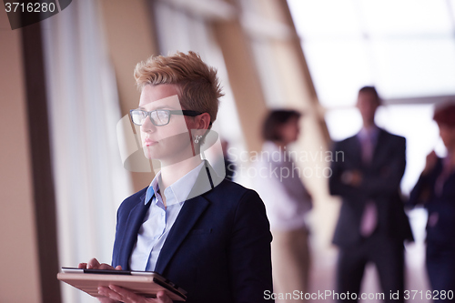 Image of business woman with glasses  at office with tablet  in front  as