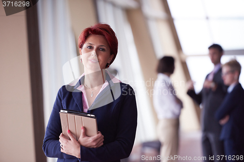 Image of business woman  at office with tablet  in front  as team leader