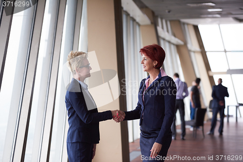 Image of business womans make deal and handshake