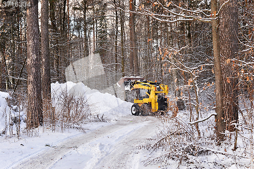 Image of The tractor clears snow from the road