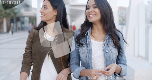 Image of Two young women strolling down a promenade