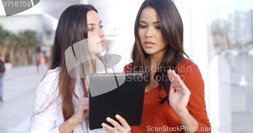 Image of Young woman looking at a tablet outdoors