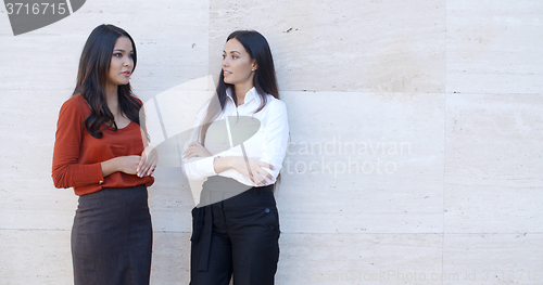 Image of Two relaxed confident ladies standing chatting