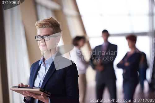 Image of business woman with glasses  at office with tablet  in front  as