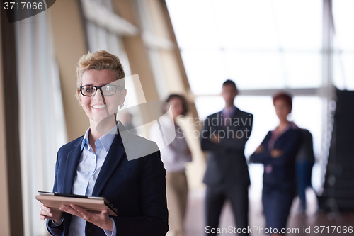 Image of business woman with glasses  at office with tablet  in front  as