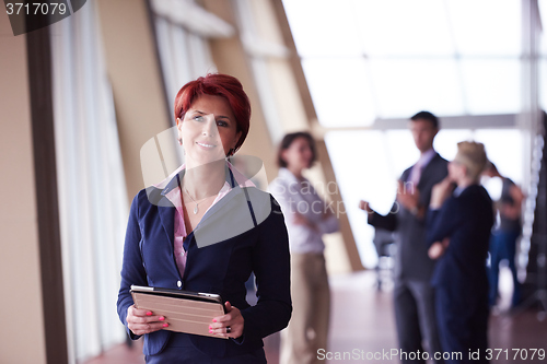Image of business woman  at office with tablet  in front  as team leader