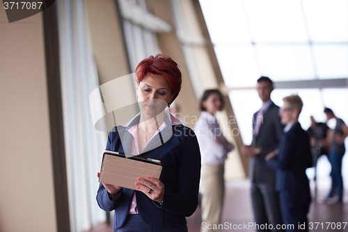 Image of business woman  at office with tablet  in front  as team leader