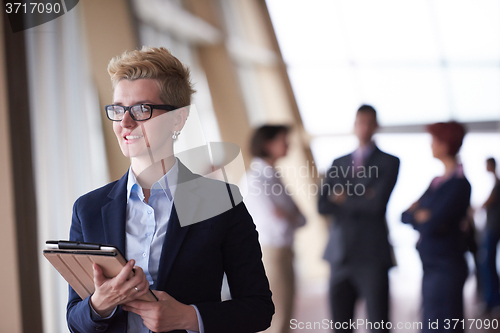 Image of business woman with glasses  at office with tablet  in front  as