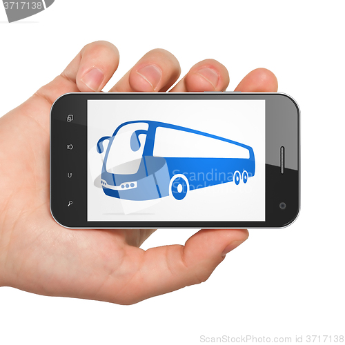 Image of Travel concept: Hand Holding Smartphone with Bus on display