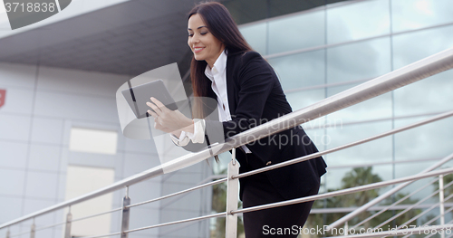 Image of Young businesswoman browsing on her tablet