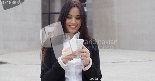 Image of Attractive businesswoman checking her mobile phone