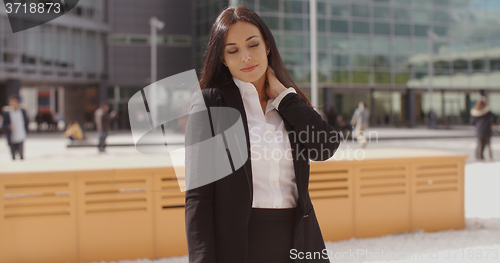 Image of Smart young businesswoman rubbing her neck