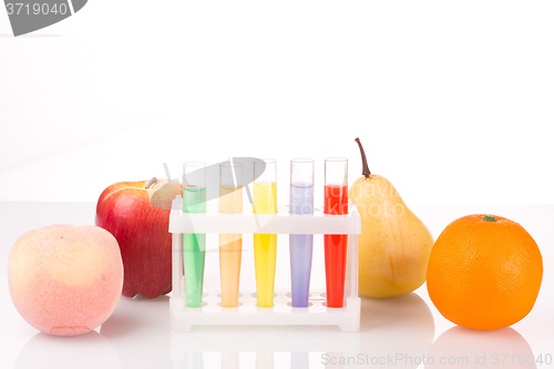 Image of Fruit close chemical test tubes. Genetic Engineering. pesticides in foods