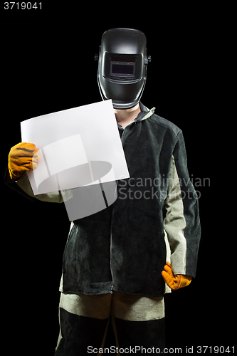 Image of handsome welder holding a blank form. isolated on black background