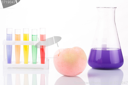 Image of Fruit close chemical test tubes. Genetic Engineering. pesticides in foods