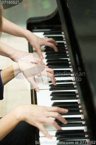 Image of Women\'s hands on the keyboard of piano. girl plays music 