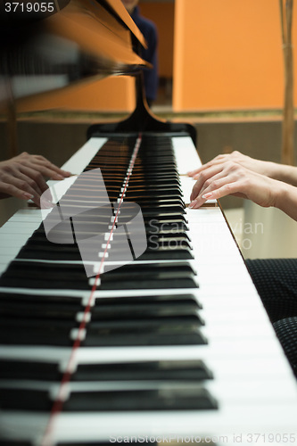 Image of Women\'s hands on the keyboard of piano. girl plays music 