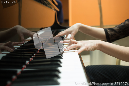 Image of Women\'s hands on the keyboard of piano. girl plays music 