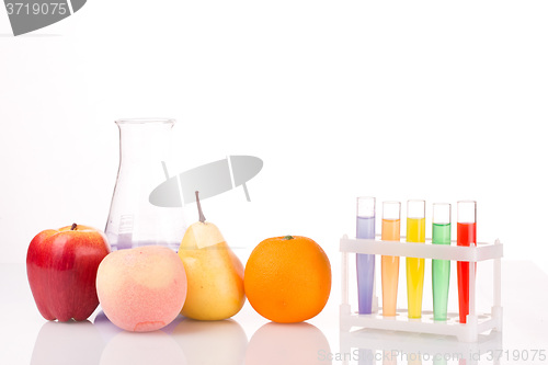 Image of Fruit close chemical test tubes. Genetic Engineering. pesticides in foods