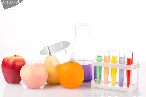 Image of Fruit close chemical test tubes. Genetic Engineering. pesticides in foods