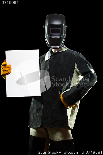 Image of handsome welder holding a blank form. isolated on black background