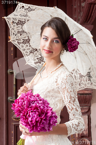 Image of Beautiful young smiling woman with flowers