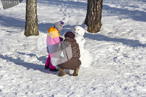 Image of Daughter and Mom make snowmen