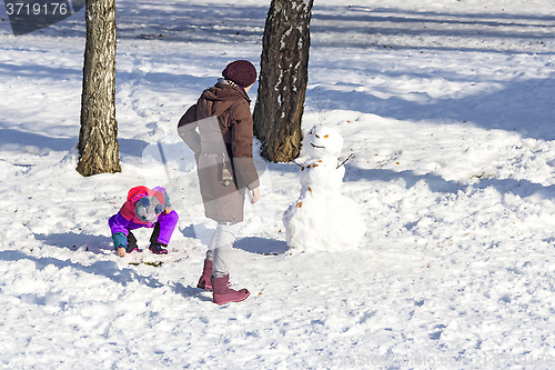 Image of Mom and daughter make snowmen