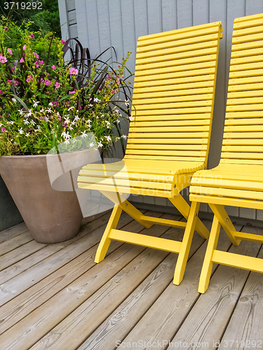 Image of Patio decorated with yellow chairs and flowers