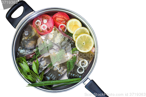 Image of Fish and components for her preparation in a large skillet.