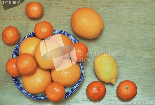 Image of Oranges and tangerines in a beautiful ceramic vase.