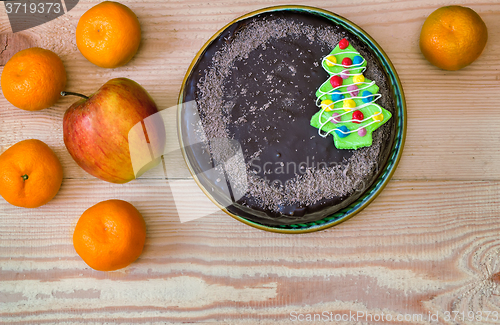 Image of Chocolate cake and fruit: apples and tangerines.