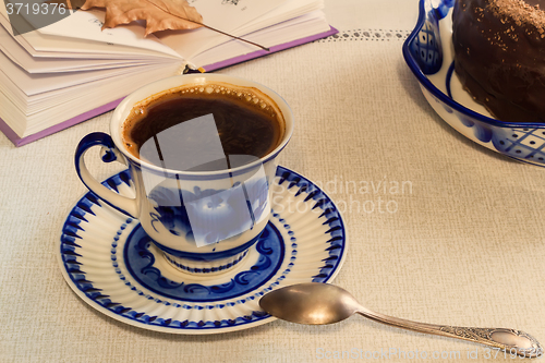 Image of A Cup of black coffee and cake on the table.