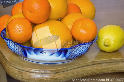 Image of Oranges and tangerines in a beautiful ceramic vase.