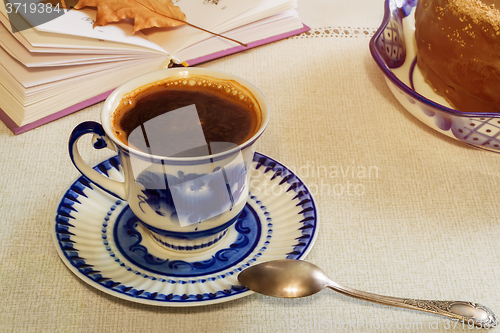 Image of A Cup of black coffee and cake on the table.