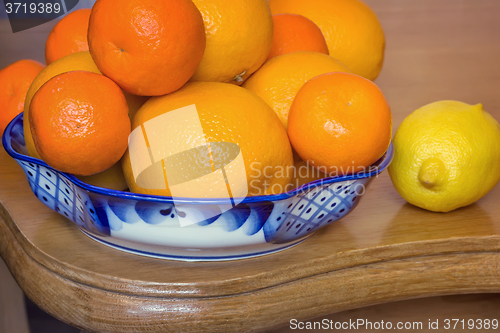 Image of Oranges and tangerines in a beautiful ceramic vase.