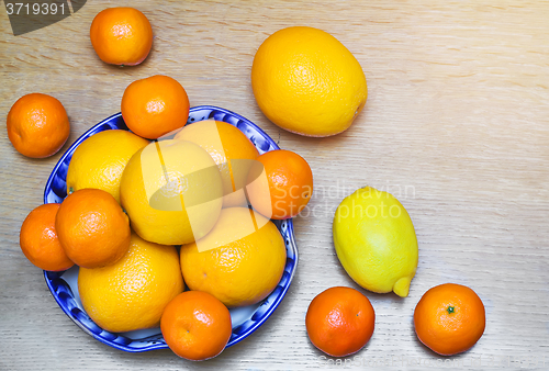 Image of Oranges and tangerines in a beautiful ceramic vase.