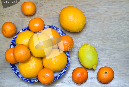 Image of Oranges and tangerines in a beautiful ceramic vase.