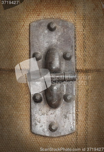 Image of Old canvas trunk hinge close up