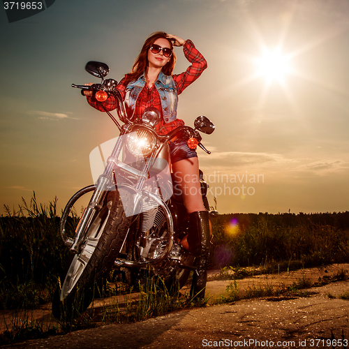 Image of Biker girl sitting on motorcycle