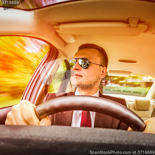 Image of Man driving a car.