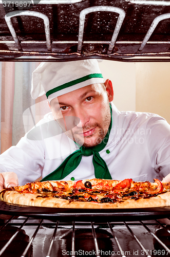 Image of Chef cooking pizza in the oven.