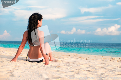 Image of Girl walking along a tropical beach in the Maldives.